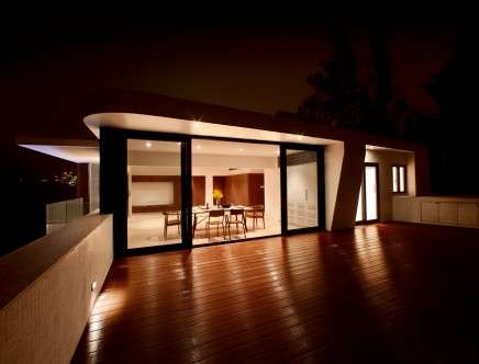 Nighttime photograph of Penthouse living and dining room from terrace. Photo: Margotpolo Productions Ltd.
